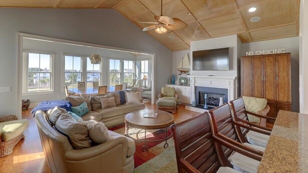 A spacious living room with a large sofa, a coffee table, and a fireplace. There is a 'No Smoking' sign on the wall and a ceiling fan. - 21 Ocean Point (Isle of Palms)
