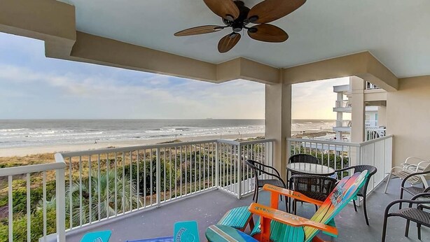 A balcony with a view of the ocean, a ceiling fan, and outdoor furniture. - 1010 Ocean Palms 201 (Isle of Palms)