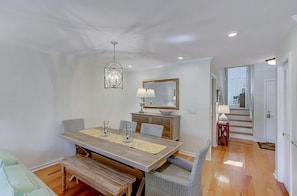 A dining area with a wooden table, chairs, and a chandelier.