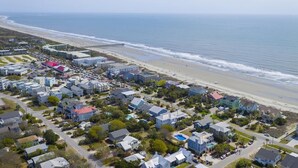 An aerial view of a coastal residential area with houses, a beach, and a pier. - 903 Ocean Boulevard (Isle of Palms)
