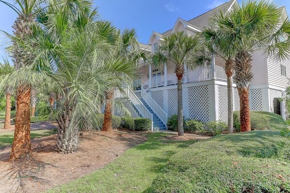 A beachfront property with a white building, a covered porch, and palm trees. - 17 56th Avenue (Isle of Palms)