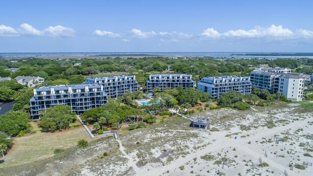 Ett hotellkomplex vid kusten med flera byggnader, en swimmingpool och ett område med strand.