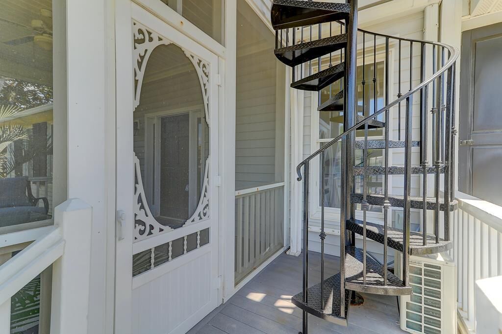 A white building with a spiral staircase and a decorative window.