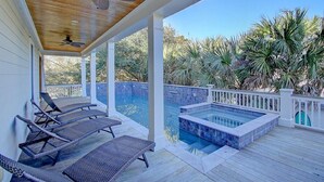 A covered outdoor area with a pool, lounge chairs, and a ceiling fan. - 2603 Palm Boulevard (Isle of Palms)