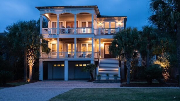 A two-story house with a balcony on the upper floor, a garage, and surrounded by palm trees. - 2603 Palm Boulevard (Isle of Palms)