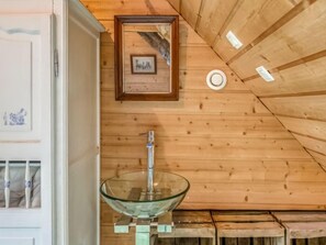 A bathroom with a glass bowl sink, wooden ceiling, and a framed picture on the wall. - Le Patio by Interhome (Saint Malo)