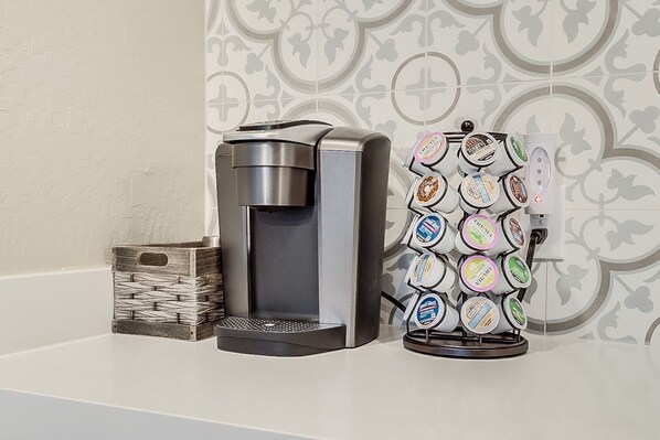 A coffee machine and a dispenser with multiple coffee pods on a countertop. - Your Home Away from Home with Heated Pool and Hot Tub (Scottsdale)