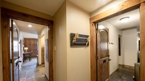 Un corridoio con porte in legno, un cartello con la scritta 'Welcome' e un pavimento piastrellato.