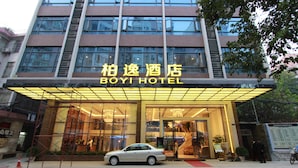 The exterior of BOYI HOTEL with a modern facade, large windows, and a prominent entrance. - Bo Yi Hotel (Guangzhou)