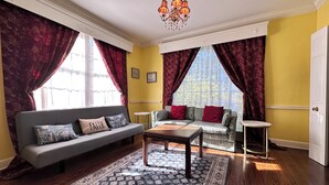 A living room with a sofa, armchair, coffee table, and patterned rug. - Filmed in Movie-Large Charming Midtown 4000 f²,5 BR,8 beds,3.5 bath sleeps 14 (Memphis)