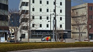 Un hotel alto con un letrero amarillo que indica que ofrece desayuno saludable.