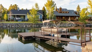 A lakeside dock with a boat, a wooden pier, and two houses in the background. - Cozy and lakefront cabin on Rainbow lake, large fenced deck and 2 grills!!! (Pinetop-Lakeside)