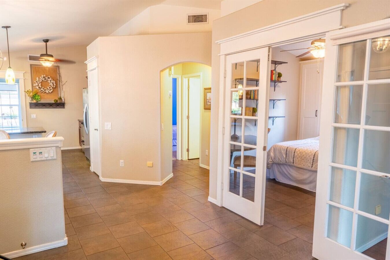 A spacious living area with a kitchen, a dining area, and a bedroom with a large window.