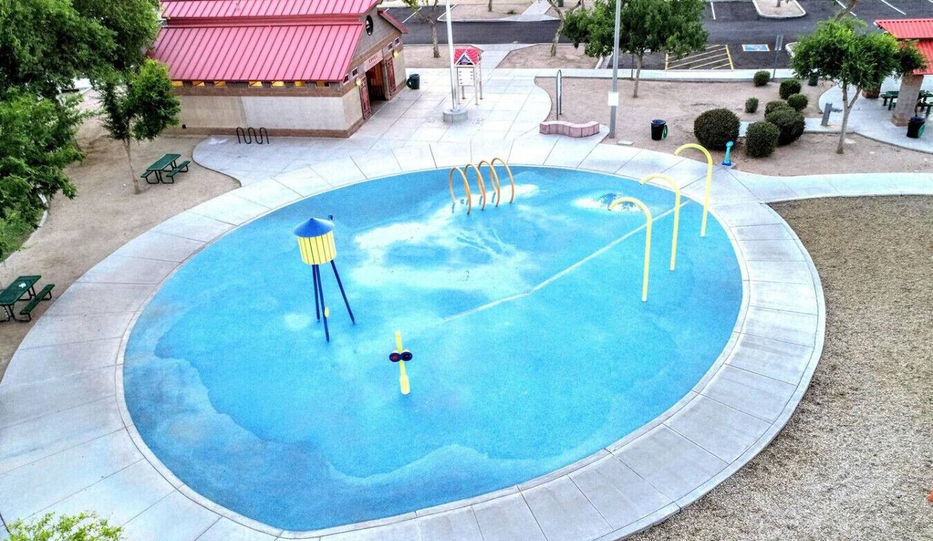 A circular pool with multiple diving boards and a water slide.