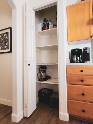 A kitchen with white cabinets, a coffee maker, and a stand mixer.