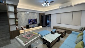 Una sala de estar moderna con sofá, mesa de centro y mueble de entretenimiento.