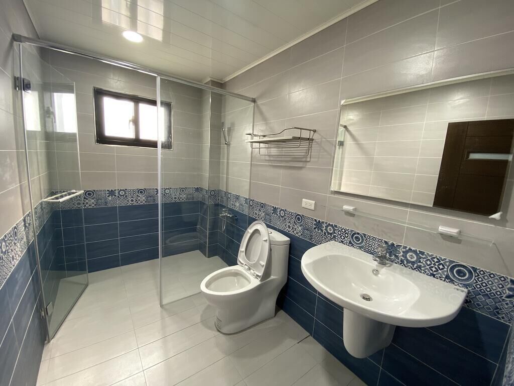 A bathroom with a toilet, sink, and shower.