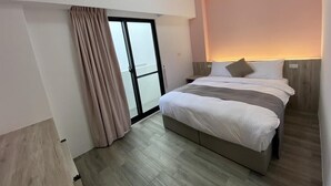 Una habitación de hotel moderna con una cama, una puerta corrediza a un balcón y un equipo de aire acondicionado.