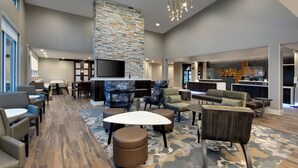 A spacious lobby with a stone accent wall, a flat-screen TV, and modern seating arrangements. - Residence Inn by Marriott Waco South (Waco)