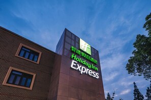 Placa do Holiday Inn Express em um edifício sob um céu claro.