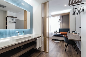 Casa de banho moderna com duas pias, espelho e porta-toalhas.