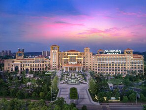 Un gran hotel con varias edificaciones, un patio central y un jardín bien cuidado.