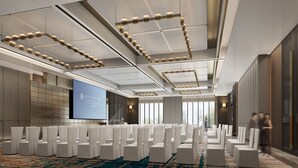 A conference room with rows of white chairs, a large screen, and a modern ceiling design. - Pullman Yueyang Hotel (Yueyang)