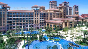 Un hôtel composé de plusieurs immeubles de grande hauteur, doté d’une grande piscine centrale et entouré d’espaces paysagers aménagés.