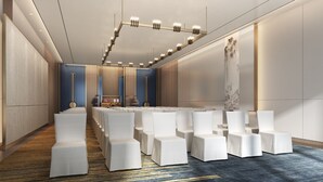 A conference room with rows of white chairs, a long table, and a modern chandelier. - Pullman Yueyang Hotel (Yueyang)
