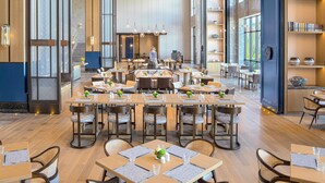 Un restaurant spacieux, doté de hauts plafonds, de grandes fenêtres et d’un mobilier moderne.