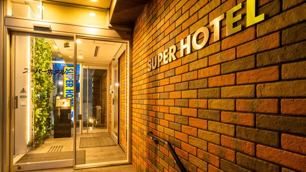 Eine Ziegelwand mit den Aufschriften "SUPER HOTEL" in großen Lettern.