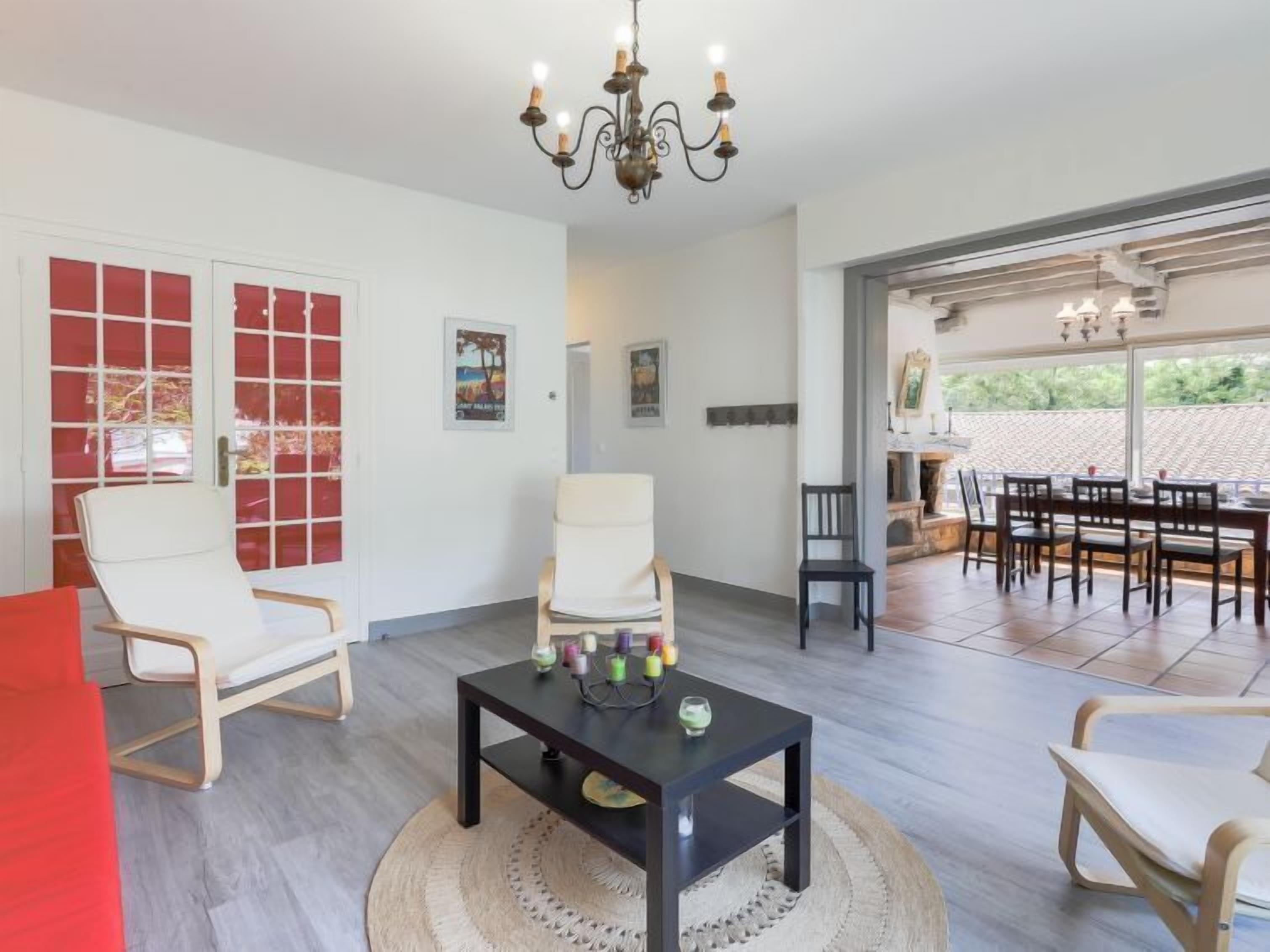 Een ruime woonkamer met een open haard, een eethoek met een grote tafel, en uitzicht op de omgeving.