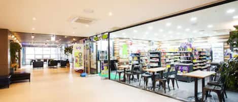 A bookstore with tables and chairs for reading, a large window, and a sign advertising a sale.
