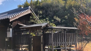 Ein traditionelles Holzhaus mit geneigtem Dach und Holzzaun.