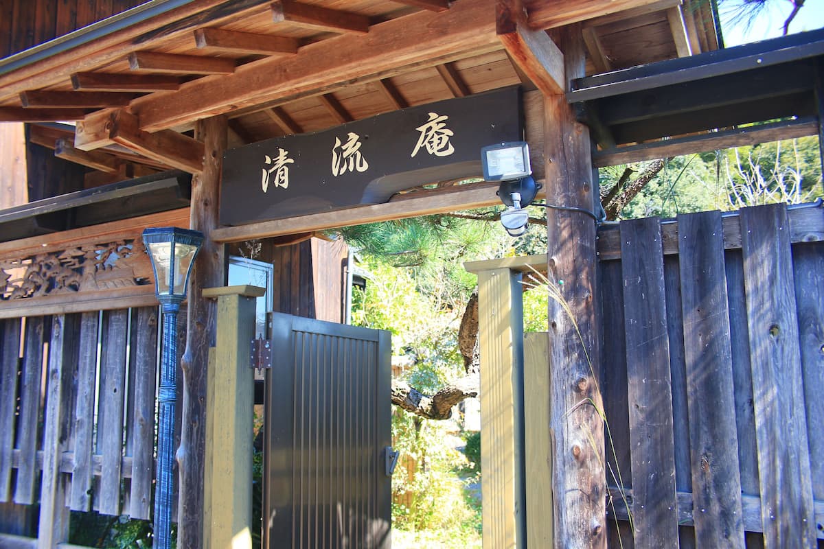 A wooden gate with a sign above it.