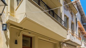 A two-story building with a wooden door, a balcony with a metal railing, and a number "106" on the facade. - Anatoli Residence - in the Old Town of Rethymno (Rethymno)