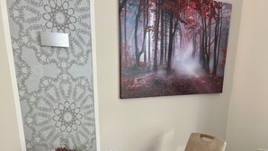 Ein Esstisch mit verschiedenen Speisen, einem Bild an der Wand und einer Wandtapete mit Muster.