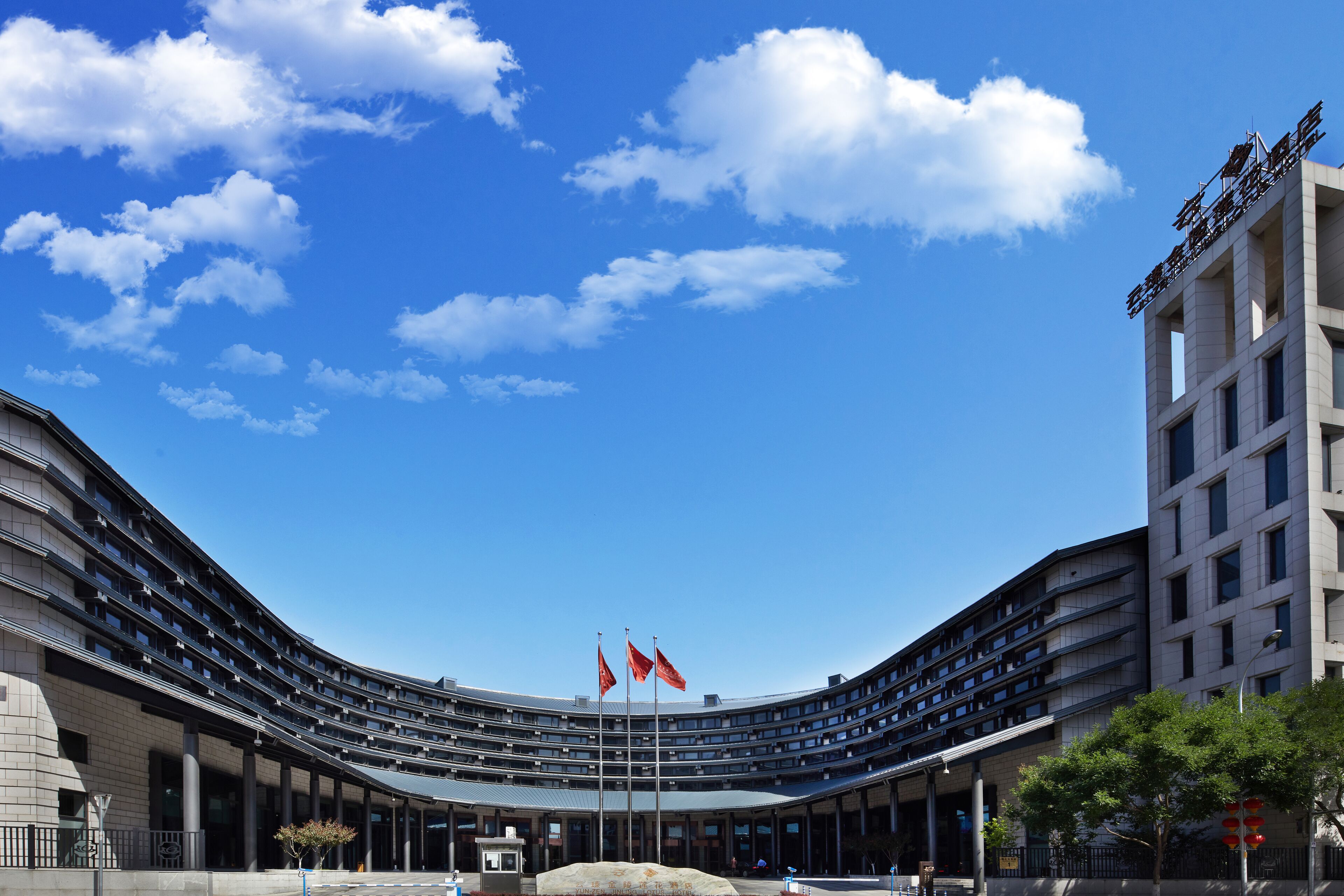 Un edificio moderno con fachada curva, varios pisos y una entrada central.