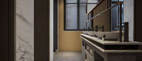 Un bagno moderno con una elegante top in marmo, un ampio specchio e una finestra con persiane.