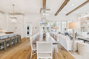 A spacious kitchen with a long dining table, white cabinetry, and a wooden ceiling. - 'Rees on Wiregrass' | Private Pool, Golf Cart, Carriage House | Lake District, WaterColor, FL (Santa Rosa Beach)