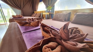 A room with a large bed, a wooden headboard, a small table with a plant, and a window with curtains. - Moonshine Resort Chumphon (Chumphon)