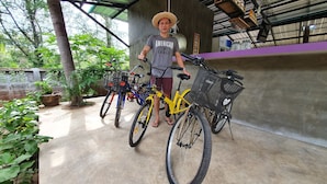 A covered outdoor area with bicycles and a person wearing a straw hat. - Moonshine Resort Chumphon (Chumphon)