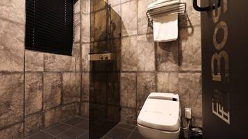 A bathroom with a shower, toilet, and towel rack.