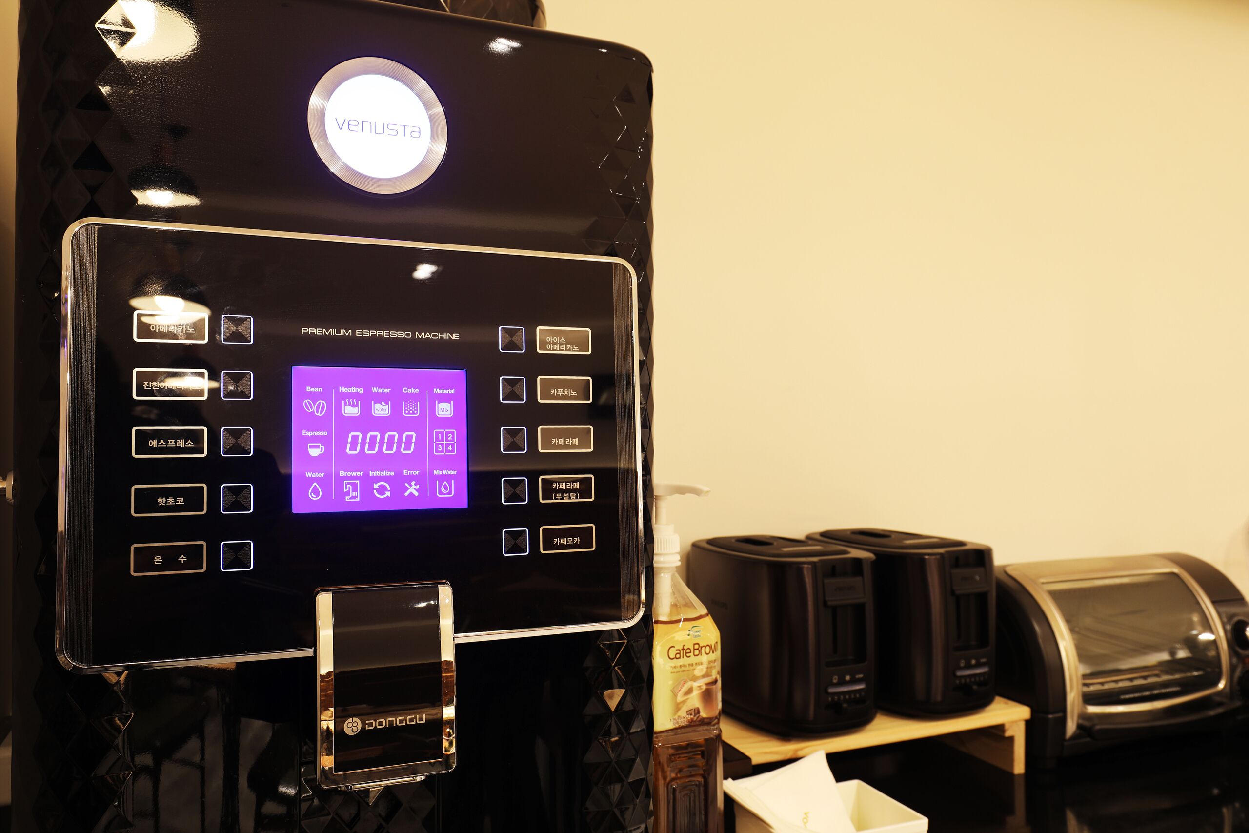 Une machine à café dotée d’un écran numérique, d’un distributeur d’eau et d’un système de préparation du café.