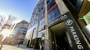 A modern building with a prominent BosCox Hotel sign and a parking area. - Wonju Boscoa Hotel (Wonju)