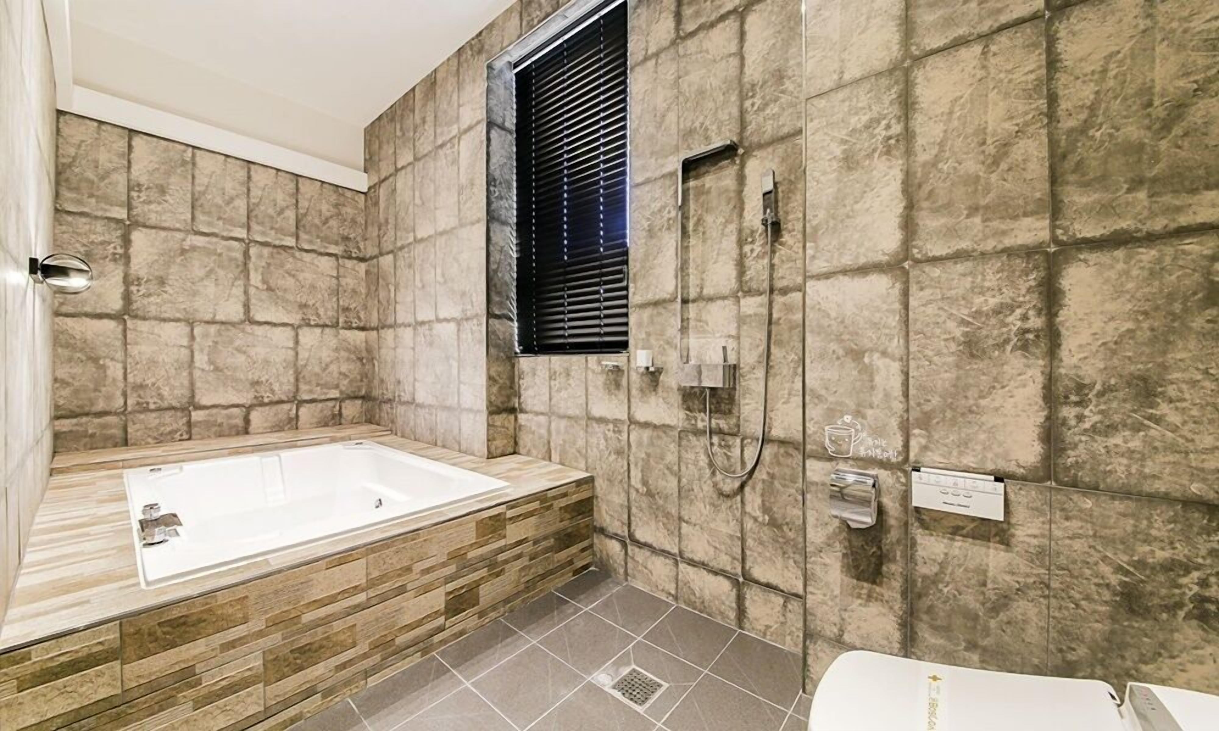 Un bagno moderno con una vasca freestanding, una zona doccia e un water.