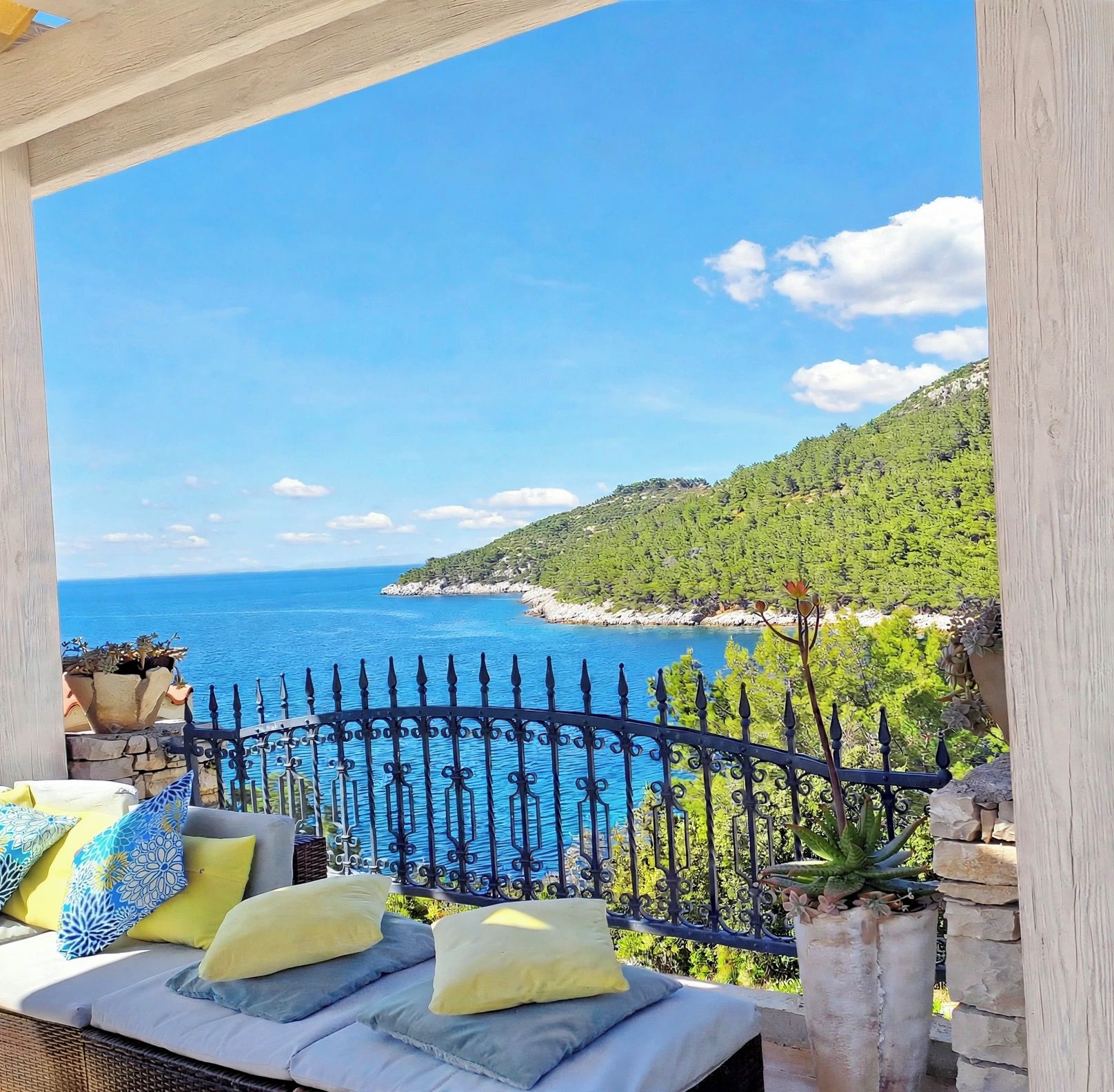 A balcony with a view of the sea and a mountainous landscape.