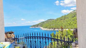 A balcony with a view of the sea and a mountainous landscape.