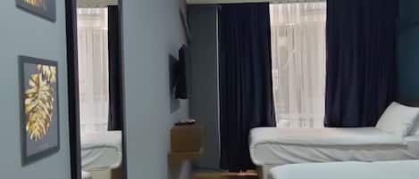 Habitación de hotel con dos camas, un espejo grande y obras de arte en las paredes.