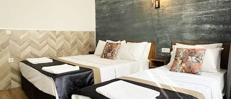 Habitación de hotel con dos camas, una pared con textura y suelo de madera.